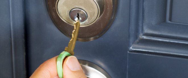Schlüssel nachmachen: Das sollten Mieter wissen. Jemand steckt einen Haustürschlüssel in ein Schloss.