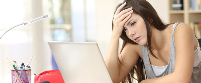 Lehrer-Beleidigung im Internet: Schülerin verurteilt. Ein junges Mädchen sitzt vor einem Laptop und stützt ihre Stirn auf einer Hand. 