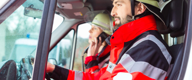 Mindestlohn gilt auch während der Bereitschaft. Ein Feuerwehrmann und eine Feuerwehrfrau sitzen in einem Feuerwehrauto.