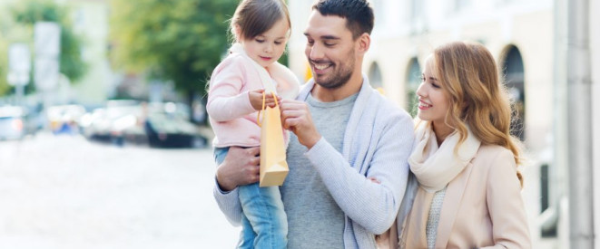 Vormundschaft für ein Pflegekind: So ist sie geregelt. Eine junge dreiköpfige Familie. Der Vater hat die Tochter auf dem Arm; die Mutter steht daneben.