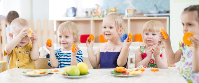 Kita-Essensgeld: Pauschale darf nicht zu hoch sein. Mehrere Kleinkinder sitzen an einem Tisch und essen Obst.