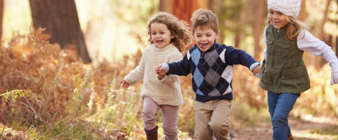 Gewaltfreie Erziehung: So schützen Kinderrechte . Drei kleine Kinder laufen einen herbstlichen Waldweg entlang.