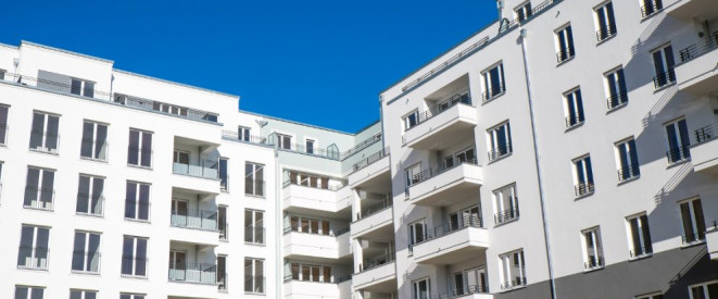 Hausverwaltung: Diese Aufgaben hat sie laut Gesetz. Eine moderne Wohnsiedlung mit weißer Fassade und Balkonen.