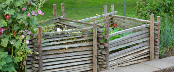 Komposthaufen im Garten: Nachbarschaftsstreit vermeiden. Zwei hölzerne Komposthaufen in einem Garten.