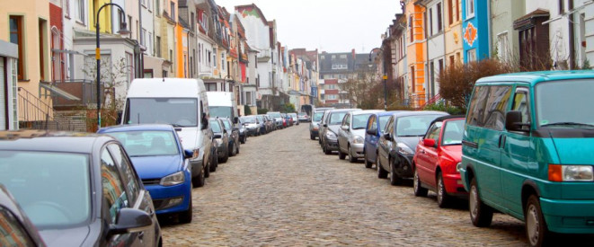 Parken entgegen der Fahrtrichtung: Wo es erlaubt ist. Autos parken am linken und rechten Fahrbahnrand einer Einbahnstraße.