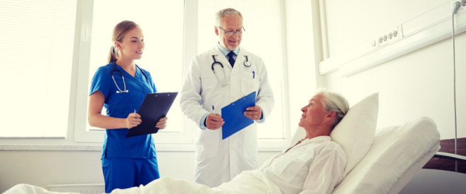 Transplantationsregister soll Organspende erleichtern. Eine ältere Frau liegt in einem Krankenhausbett. Neben ihr steht ein Arzt in weißem Kittel und eine Krankenschwester in blauer Kleidung.