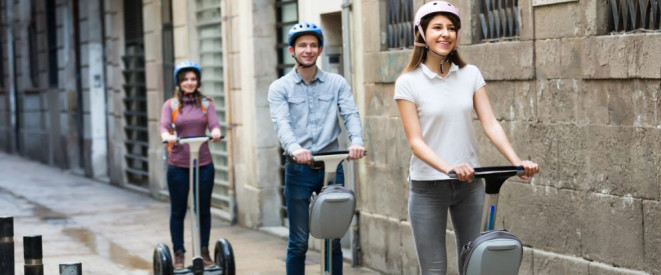 Segway fahren: Führerschein und weitere Voraussetzungen. Ein junger Mann und zwei junge Frauen fahren auf einem Segway.