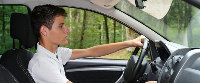 Zu schnell und Unfall in der Probezeit: Führerschein weg. Ein junger Mann sitzt hinter dem Steuer eines Autos.