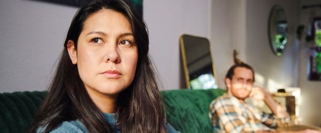 Pärchen sitzt traurig voneinander abgewandt auf dem Sofa