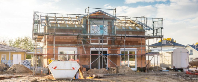 Halb fertiges Haus auf einer Baustelle im Neubaugebiet