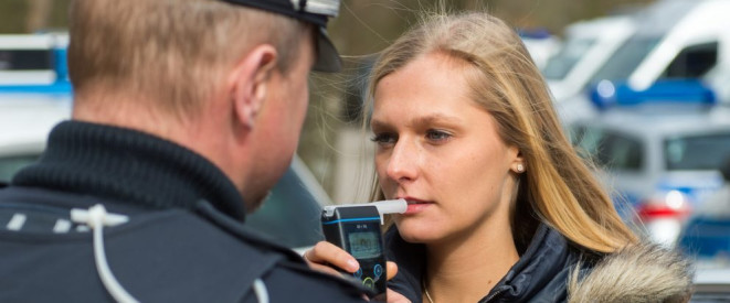Frau bei einer Alkoholkontrolle mit einem Polizisten