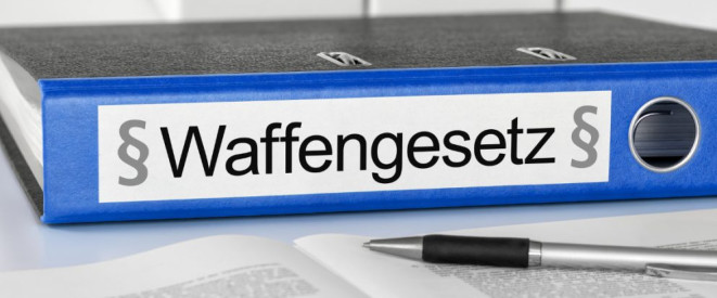 Ordner mit Aufschrift Waffengesetz und ein Stift