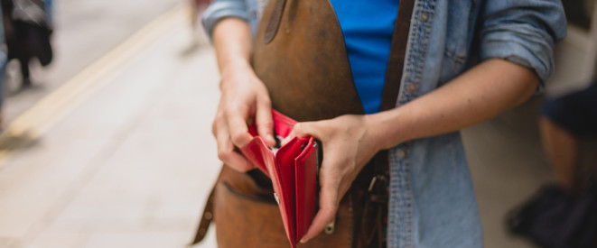 Frau hält rote Geldbörse