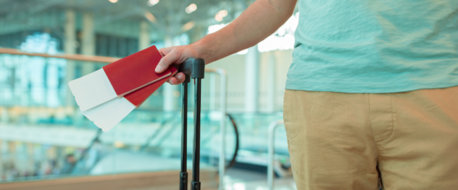 Nahaufnahme von Mensch, der Flugtickets in der Hand hält.