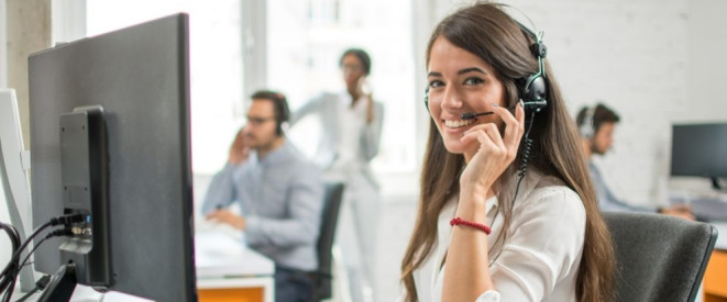 Frau im Callcenter telefoniert und lacht dabei