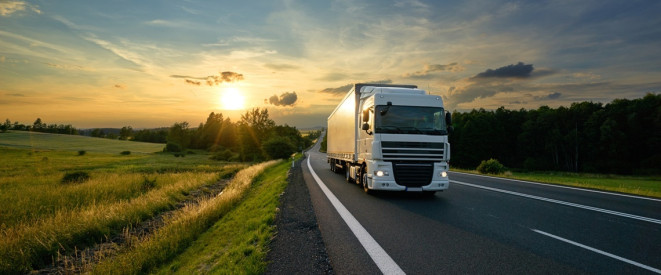 LKW auf Landstraße im Sonnenuntergang