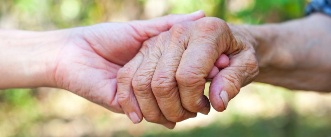 Eine junge Hand hält eine ältere Hand