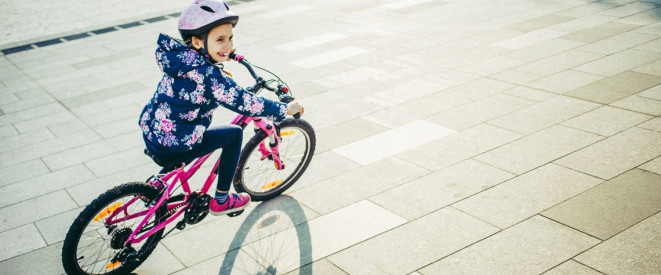 Kind fährt Fahrrad und lacht