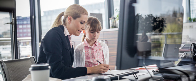 Frau sitzt mit kleinem Kind im Büro