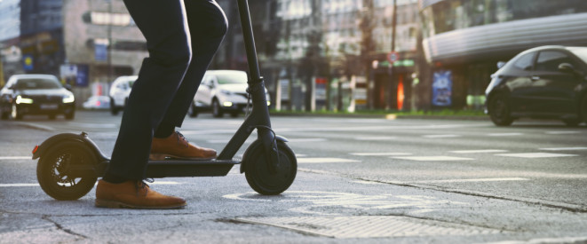 Mann im Anzug auf einem E-Scooter