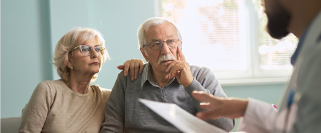 Älteres Paar auf Sofa Gespräch mit Mann mit Vertrag