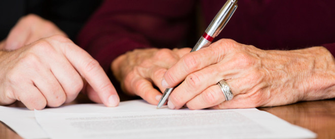 Alte Person unterschreibt Testament