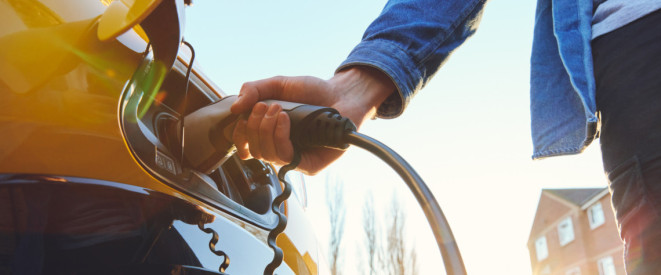 Person lädt Elektroauto auf