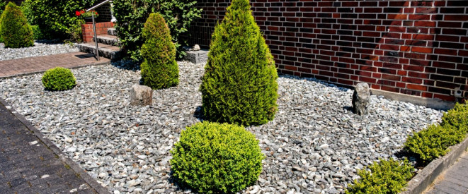 Vorgarten aus Stein, Kies und Schotter mit wenigen Buchsbäumen