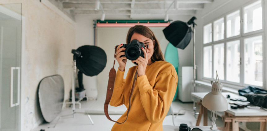 Frau in Studio macht Foto mit Kamera