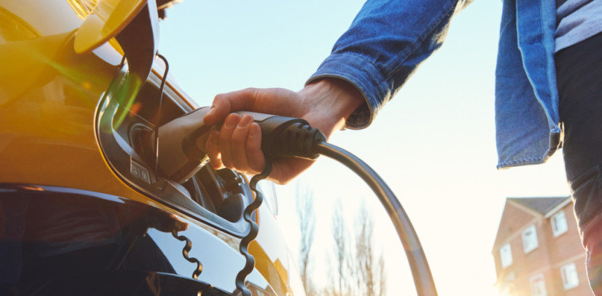 Person lädt Elektroauto auf