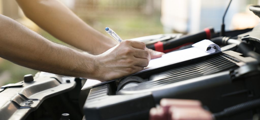 Techniker kontrolliert den Motor eines Autos.