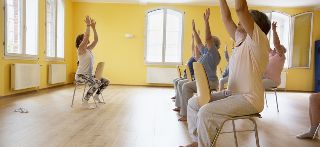 Yogalehrerin trainiert mit einer Senioren-Yogaklasse.