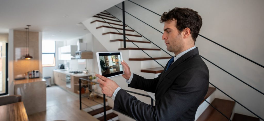 Vermieter macht Fotos von einer Wohnung mit einem Tablet.