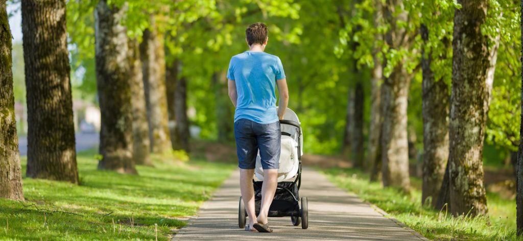 Junger Vater mit Kinderwagen