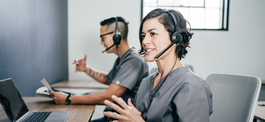 Eine Frau und ein Mann telefonieren jeweils mit Headset