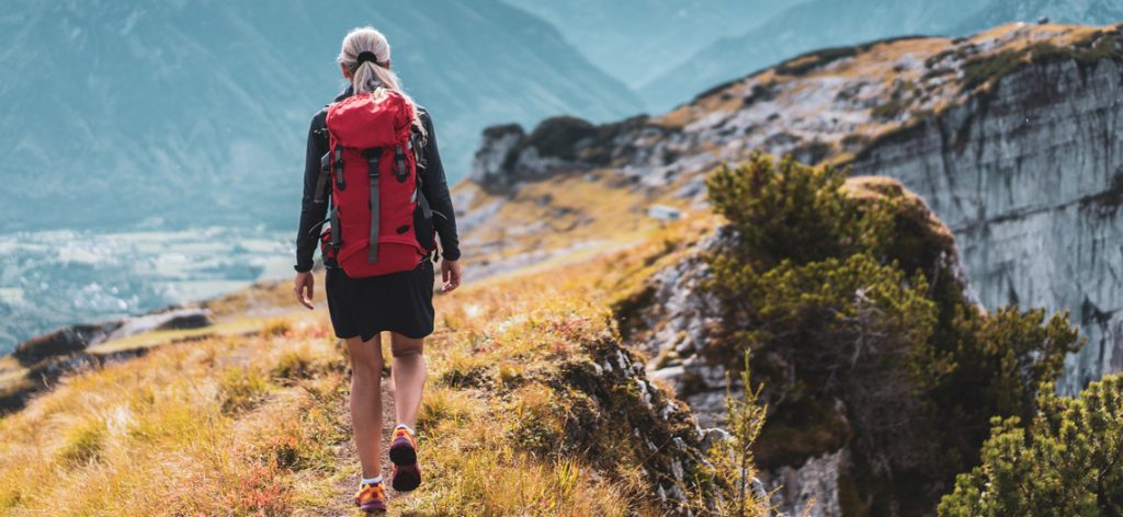 Frau mit Rucksack wandert durch die Berge.