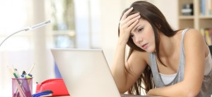 Lehrer-Beleidigung im Internet: Schülerin verurteilt. Ein junges Mädchen sitzt vor einem Laptop und stützt ihre Stirn auf einer Hand.