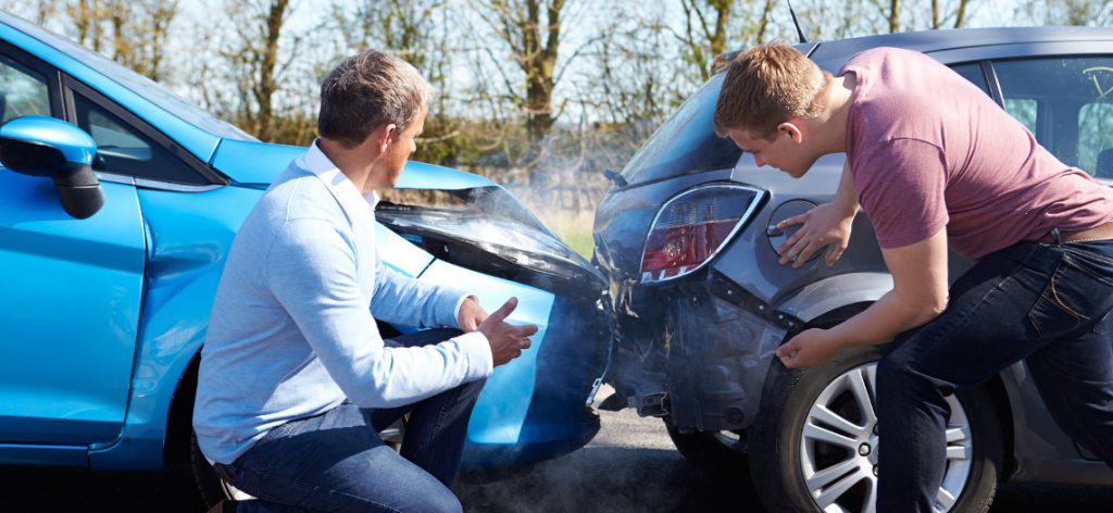 Anscheinsbeweis bei Auffahrunfall: Klärung der Schuldfrage. Zwei Männer stehen vor Ihren Autos, die aufeinander gefahren sind.