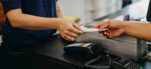 Frau gibt einen Einkaufsbon an der Kasse ab.