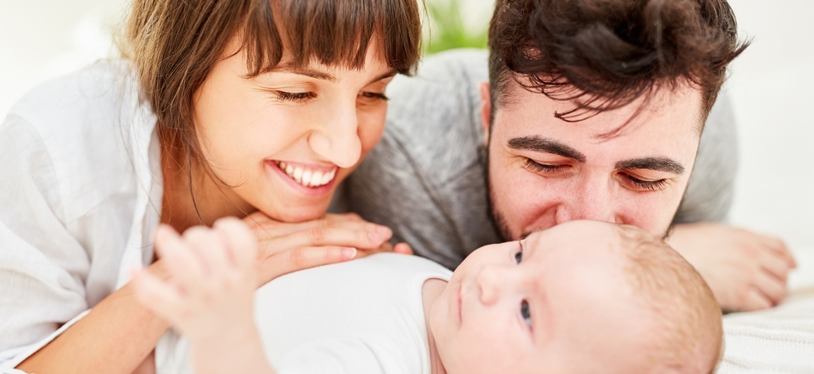 glückliches Paar schaut ein Baby an