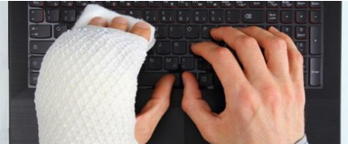 Eine Person tippt mit eingegipster linker Hand auf einer Tastatur.