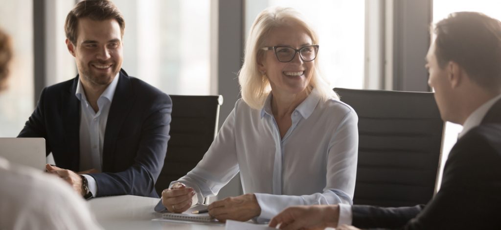 Frau sitzt in Meeting und lacht