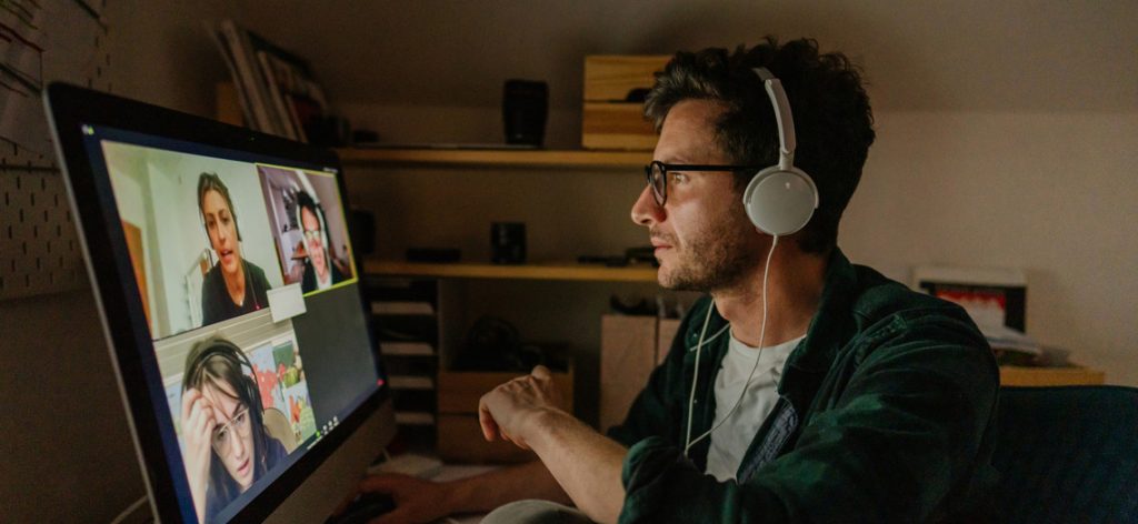 Einreise aus Corona-Risikogebieten: Das droht nach der Rückkehr Mann sitzt im Video-Chat vorm PC.
