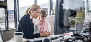 Frau sitzt mit kleinem Kind im Büro