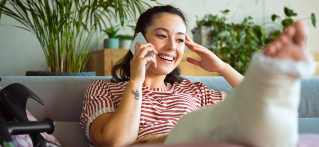 Frau mit gebrochenem Bein telefoniert