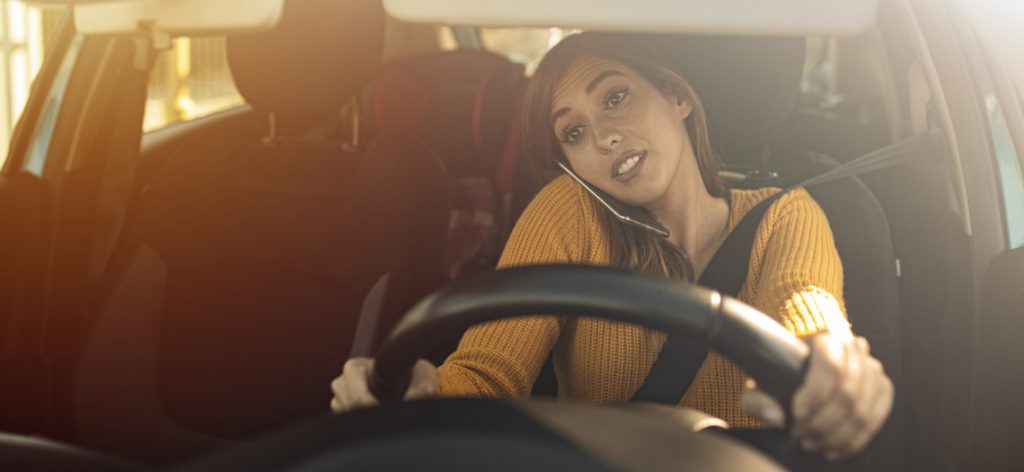 Frau telefoniert mit dem Handy während der Fahrt