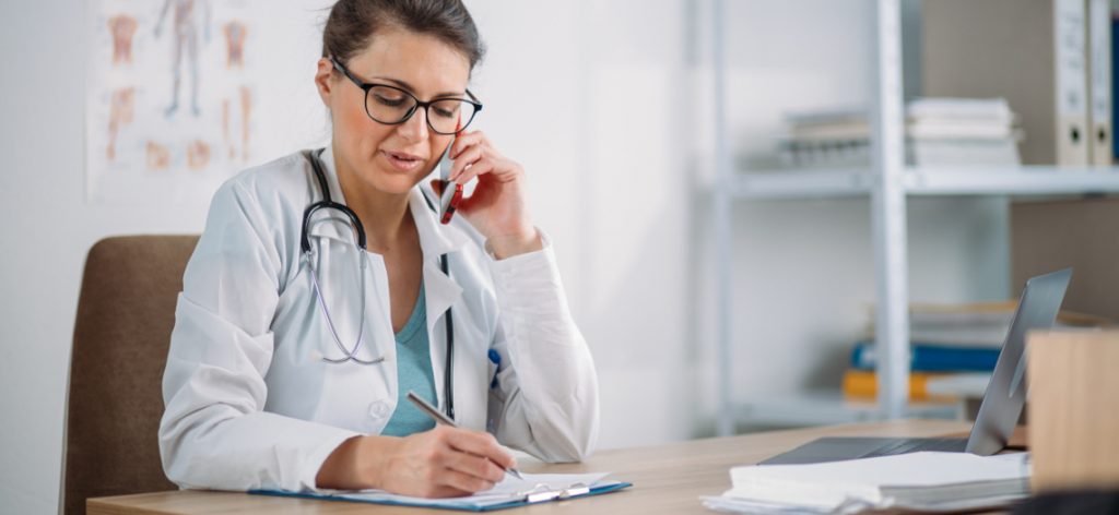 Ärztin telefoniert mit Patient.