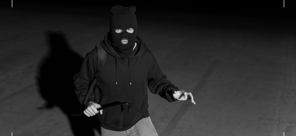 Einbrecher mit Ski-Maske aus Sicht einer Überwachungskamera