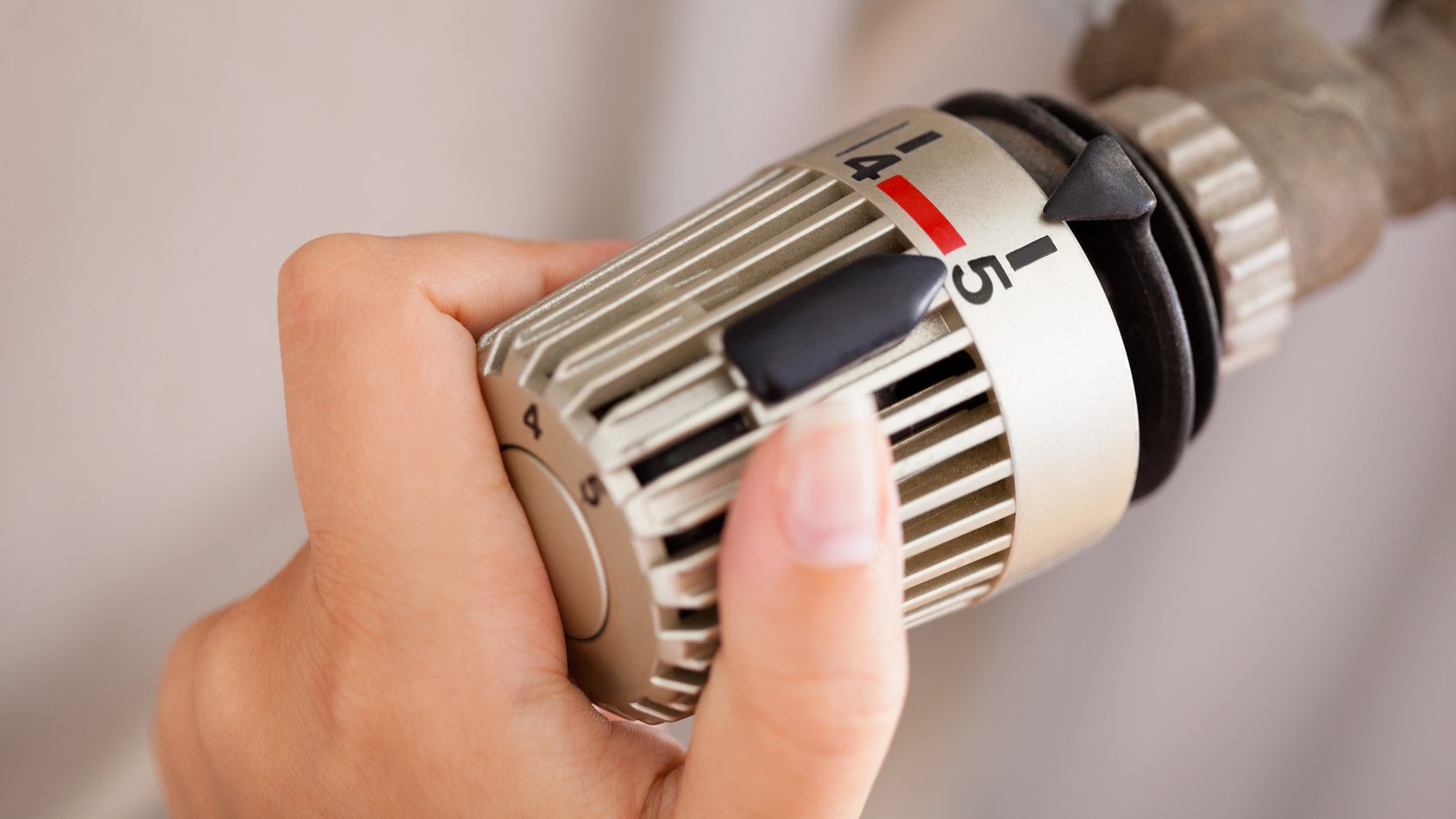 Mietminderung bei Heizungsausfall: Deine Rechte als Mieter Frau justiert das Thermostat.