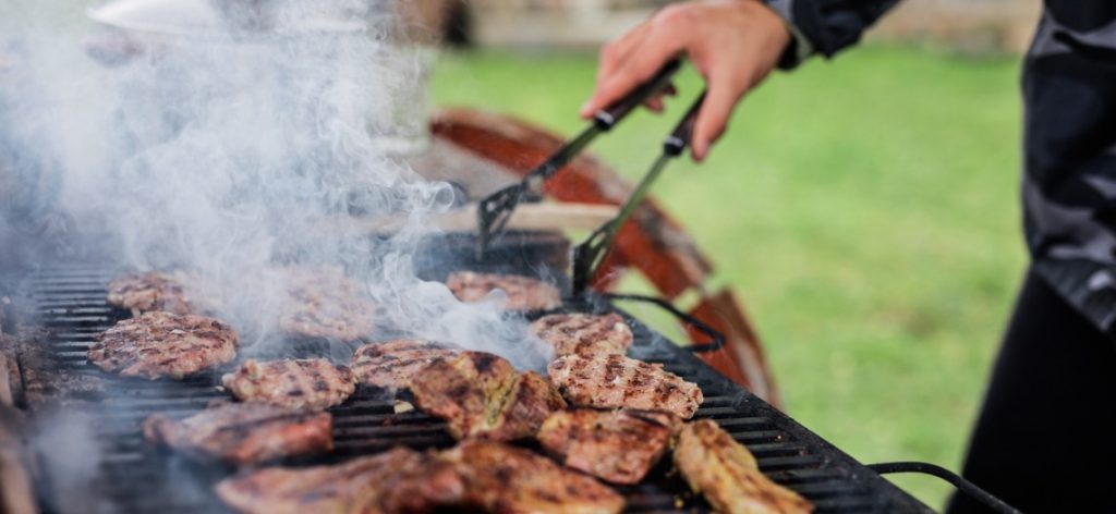 Fleisch brutzelt und qualmt auf einem Grillrost